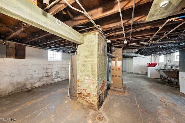 basement with electric panel, a wealth of natural light, heating unit, and independent washer and dryer