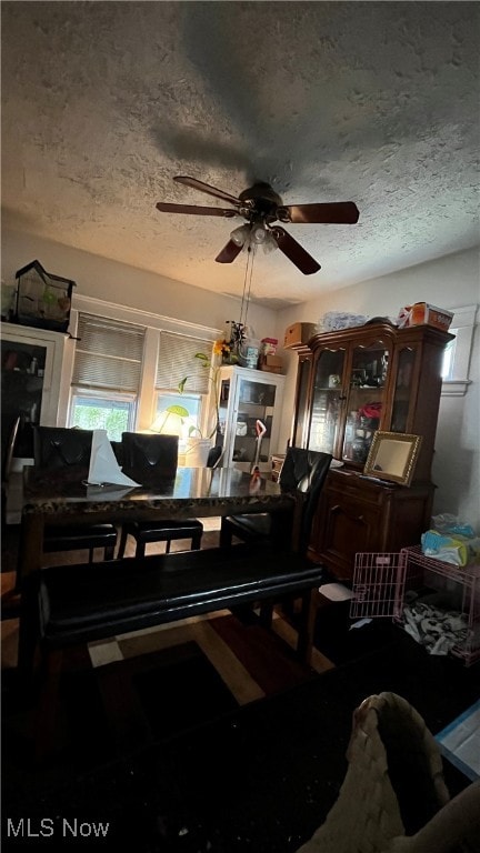 misc room with ceiling fan and a textured ceiling