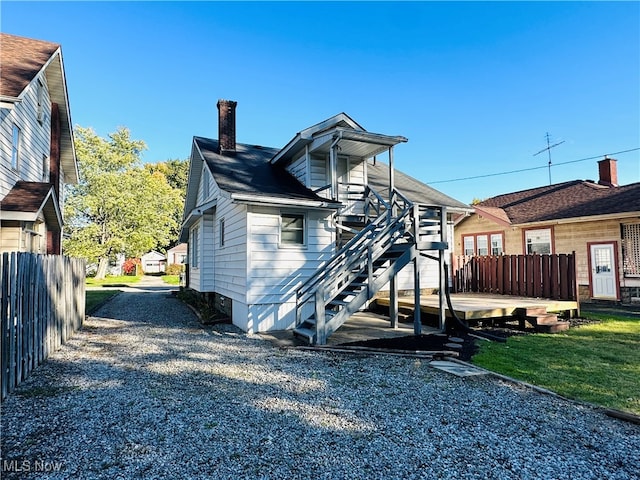 back of house with a deck and a yard