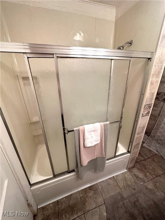 bathroom featuring combined bath / shower with glass door