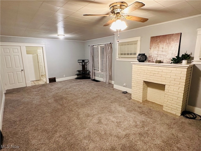 unfurnished living room with ceiling fan, light colored carpet, ornamental molding, and a brick fireplace