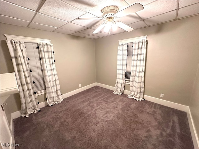 carpeted empty room with a paneled ceiling and ceiling fan