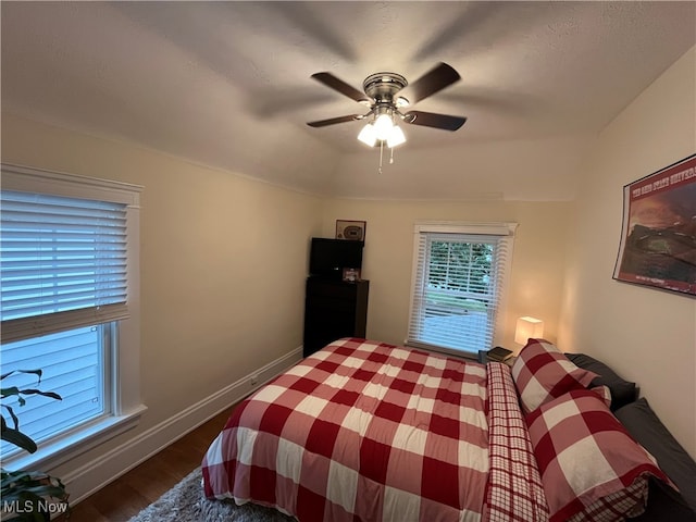 bedroom with dark hardwood / wood-style flooring and ceiling fan