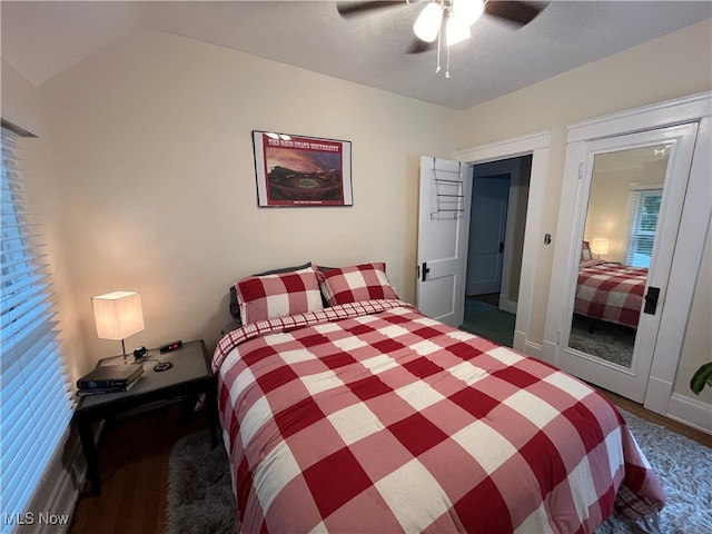 bedroom with dark wood-type flooring, vaulted ceiling, and ceiling fan