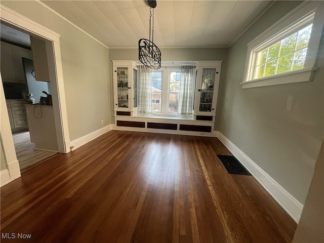 unfurnished dining area with a wealth of natural light, dark hardwood / wood-style floors, and crown molding