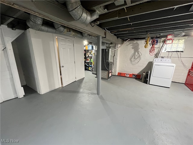 basement featuring water heater, washer / clothes dryer, and heating unit