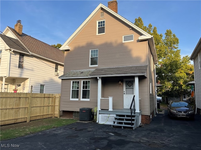 back of house with covered porch and central AC