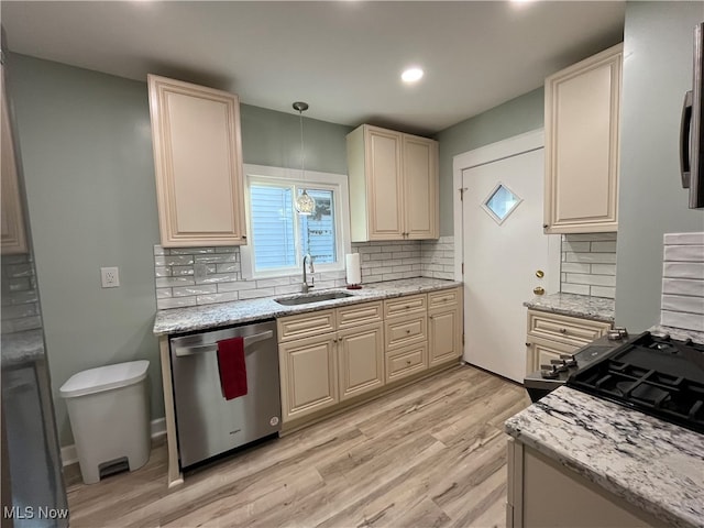 kitchen with light hardwood / wood-style floors, sink, tasteful backsplash, stainless steel dishwasher, and decorative light fixtures