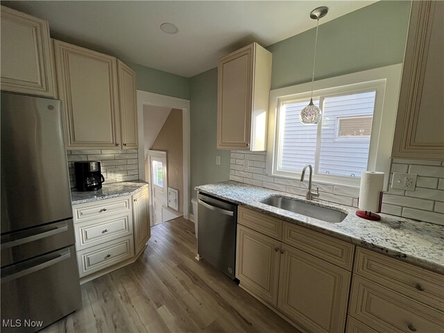 kitchen featuring pendant lighting, a wealth of natural light, stainless steel appliances, and backsplash