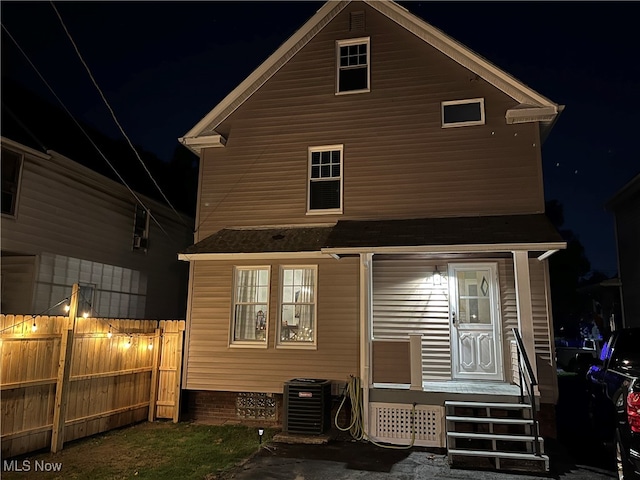 back house at twilight featuring cooling unit