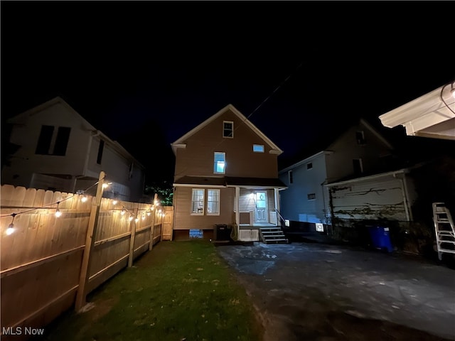 back house at night with a lawn