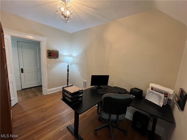 office area with dark hardwood / wood-style flooring, lofted ceiling, a textured ceiling, and an inviting chandelier