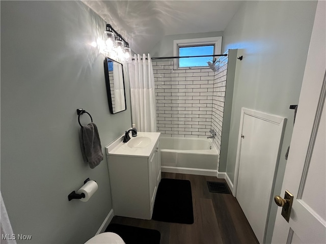 bathroom featuring hardwood / wood-style flooring, vanity, and shower / bath combo