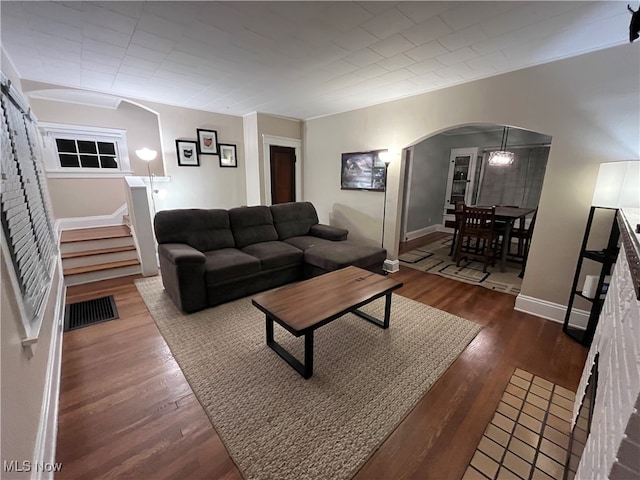 living room with dark hardwood / wood-style flooring and ornamental molding