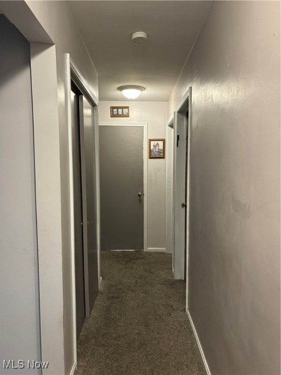 hallway with dark colored carpet