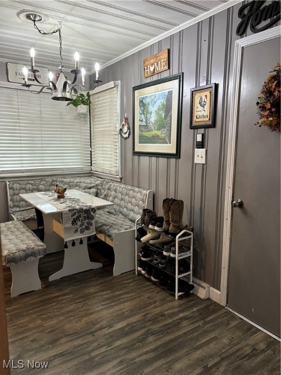 dining area with breakfast area, a notable chandelier, dark hardwood / wood-style flooring, and ornamental molding