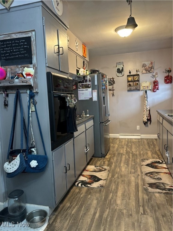 kitchen featuring black oven, a baseboard radiator, dark hardwood / wood-style flooring, and gray cabinets