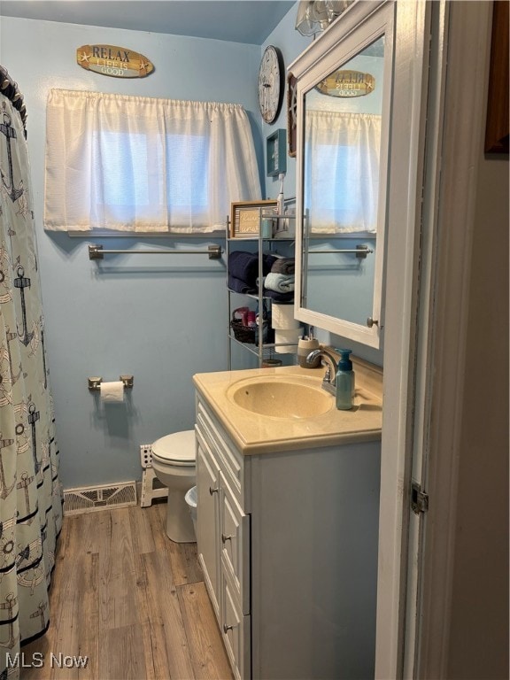 bathroom with toilet, vanity, and hardwood / wood-style flooring