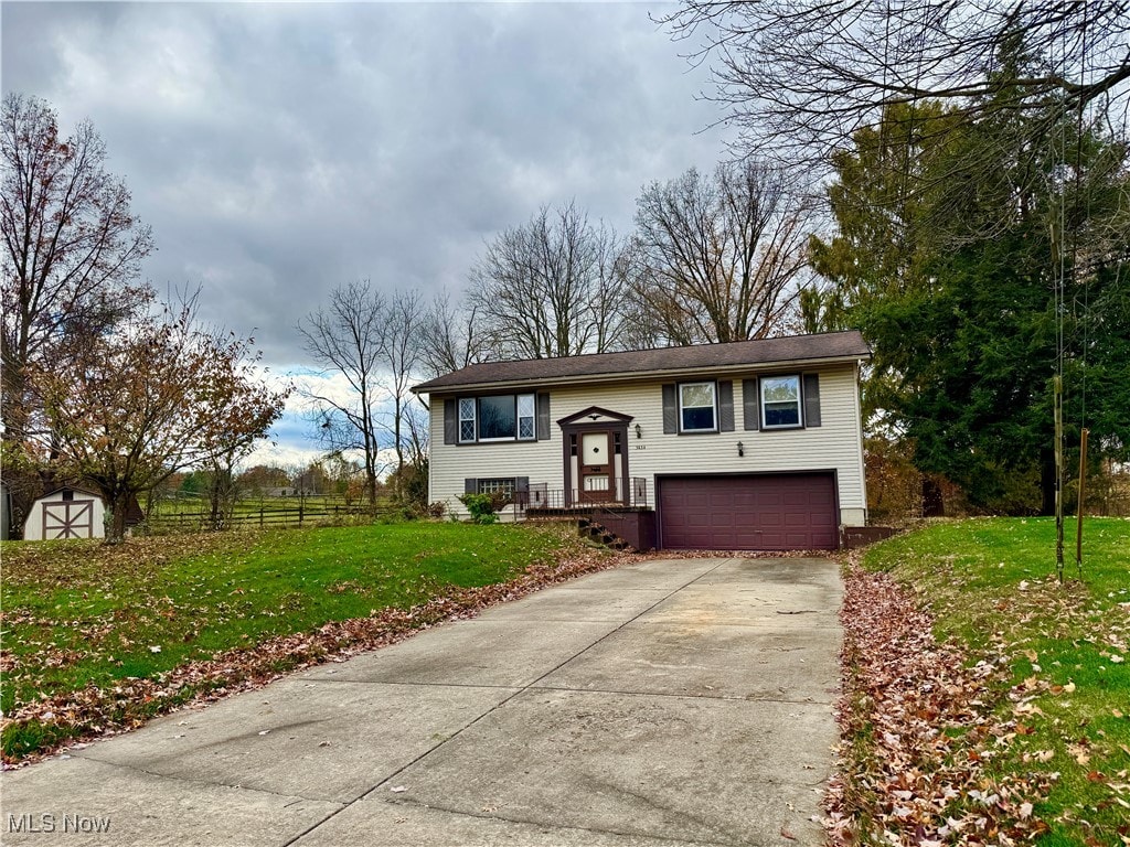 split foyer home featuring a garage and a front lawn