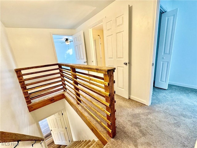 stairway with carpet flooring and ceiling fan