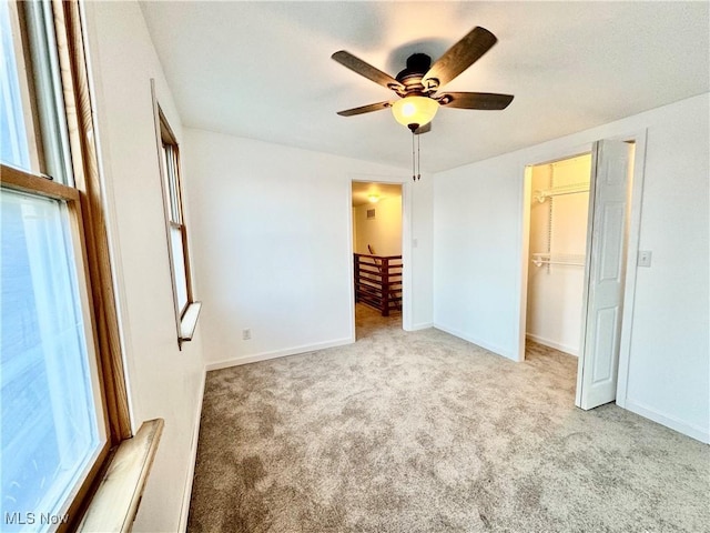 unfurnished bedroom with light carpet, a closet, and ceiling fan