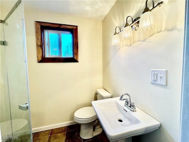 bathroom featuring a shower, toilet, and sink