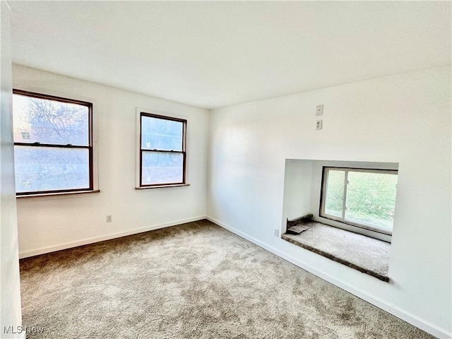 unfurnished room with carpet and a healthy amount of sunlight