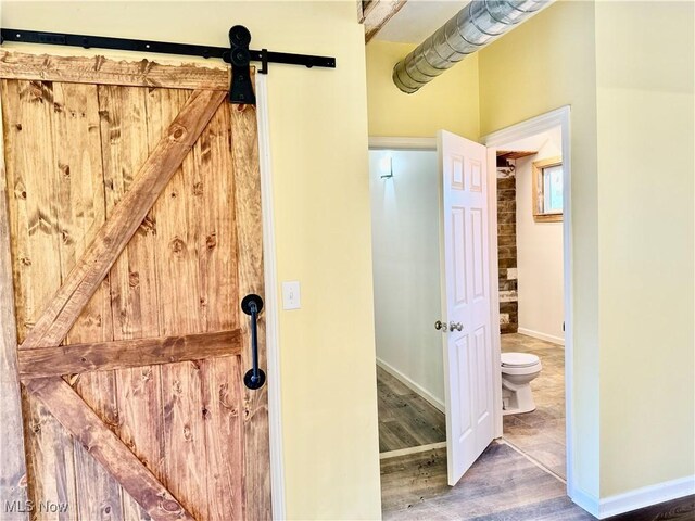 bathroom with hardwood / wood-style floors and toilet