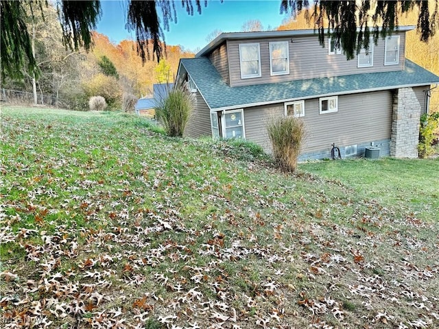 view of property exterior featuring a yard and central AC