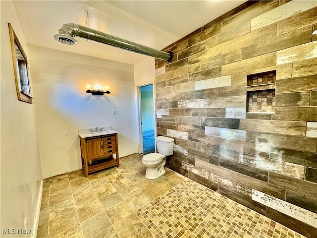 bathroom with a shower, vanity, and toilet