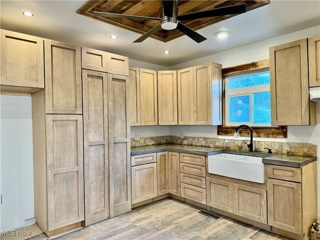 kitchen featuring ceiling fan, light brown cabinets, light wood-type flooring, and sink