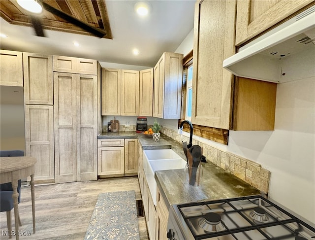 kitchen featuring electric range, light brown cabinets, light hardwood / wood-style floors, and sink