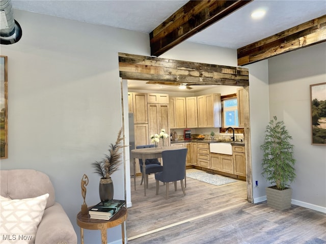 kitchen featuring light brown cabinets, hardwood / wood-style flooring, beam ceiling, and sink