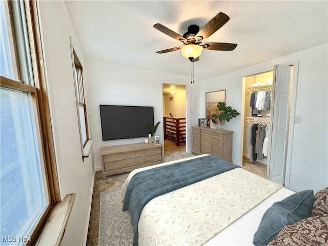 bedroom featuring ceiling fan, light colored carpet, a spacious closet, and a closet