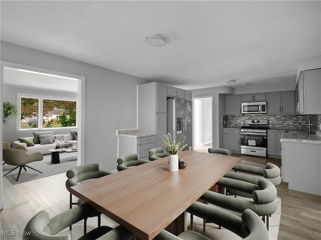 dining space featuring sink and light hardwood / wood-style flooring