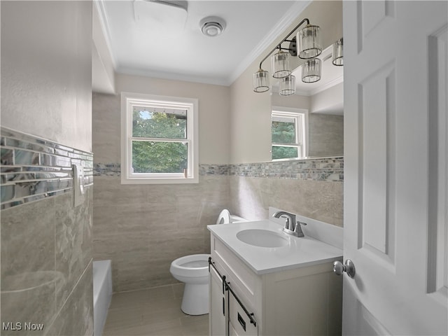 bathroom with tile walls, vanity, a wealth of natural light, and toilet