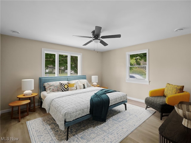 bedroom with light wood-type flooring, multiple windows, and ceiling fan