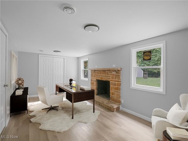 interior space featuring a stone fireplace and light wood-type flooring