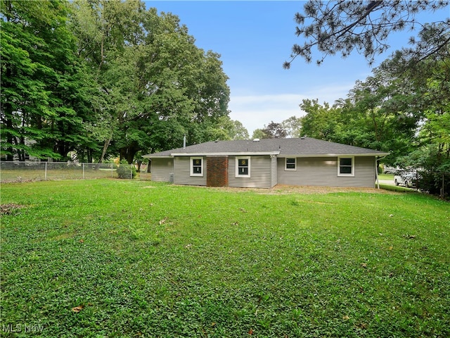 rear view of house featuring a lawn