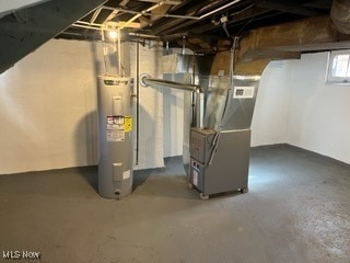 basement featuring electric water heater and heating unit