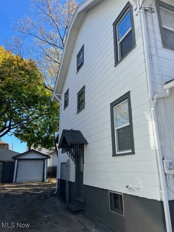 view of side of home featuring an outbuilding and a garage