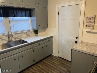 kitchen with gray cabinets, dark hardwood / wood-style floors, sink, and backsplash