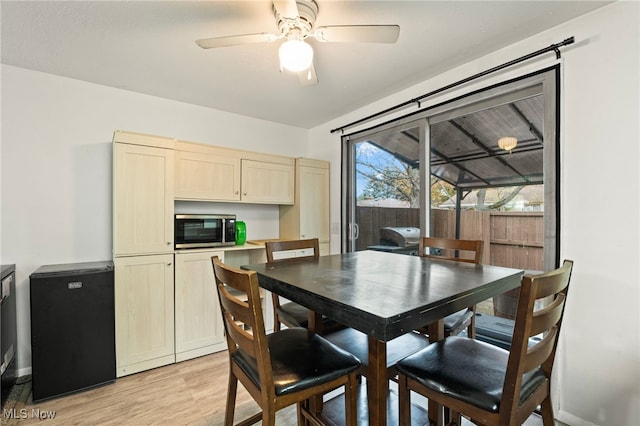 dining space with ceiling fan and light hardwood / wood-style flooring