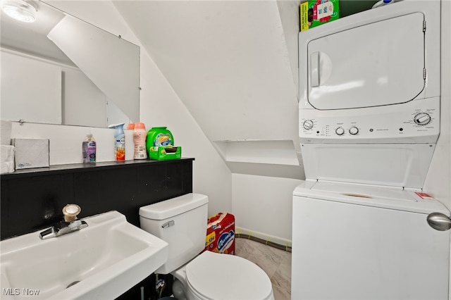 bathroom featuring hardwood / wood-style floors, stacked washer / dryer, sink, and toilet