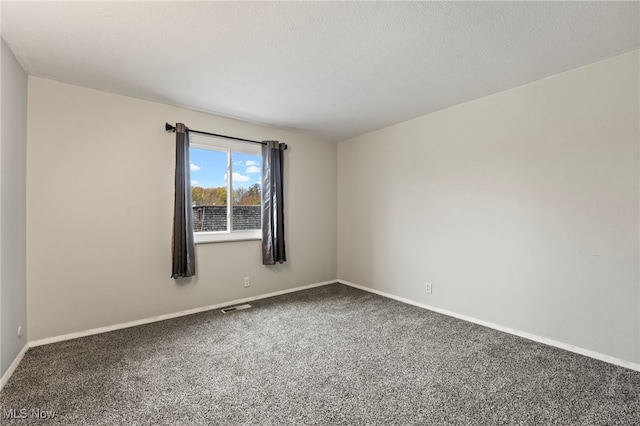 carpeted empty room featuring a textured ceiling