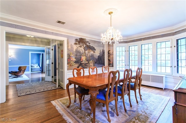 dining space with french doors, wood-type flooring, a chandelier, and crown molding