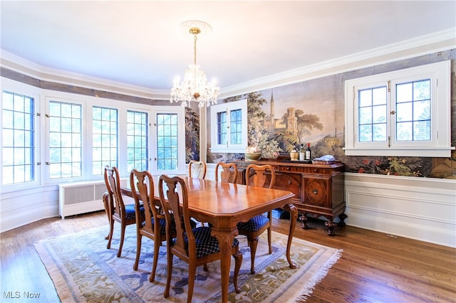 dining area with hardwood / wood-style floors, plenty of natural light, a notable chandelier, and ornamental molding