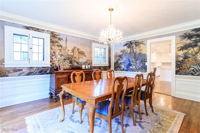 dining space with wood-type flooring, a chandelier, and crown molding