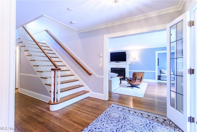 stairs with ornamental molding and wood-type flooring