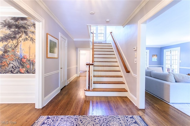 stairs featuring hardwood / wood-style floors and ornamental molding